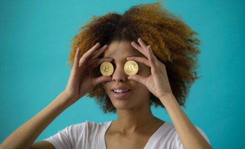 woman holding two round gold-colored coins