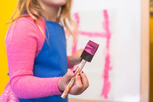 girl using pink paint brush