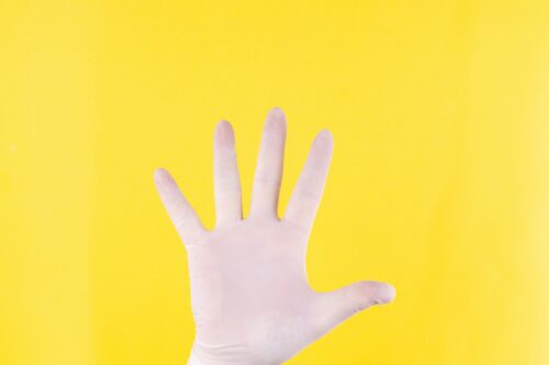 persons left hand on yellow background