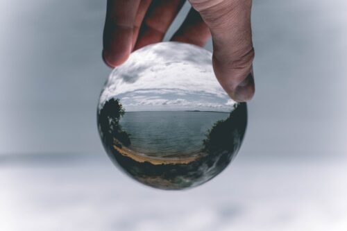 person holding orb with image of sea