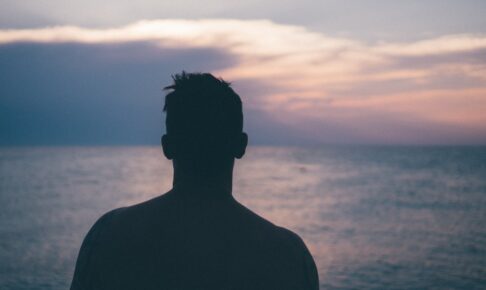 silhouette photography of man standing near sea