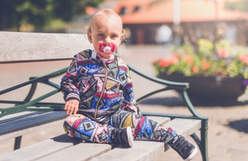 toddler sitting on wooden bench