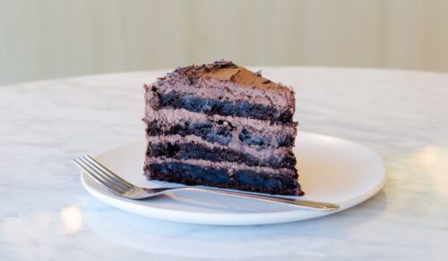 sliced chocolate cake beside fork on plate