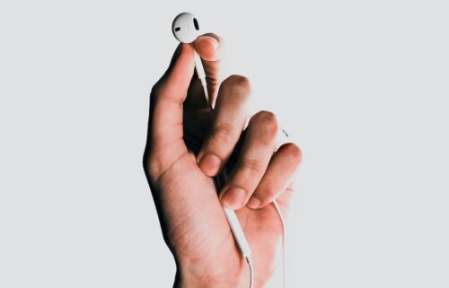 person holding Apple EarPods