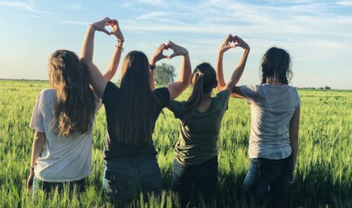 women forming heart gestures during daytime