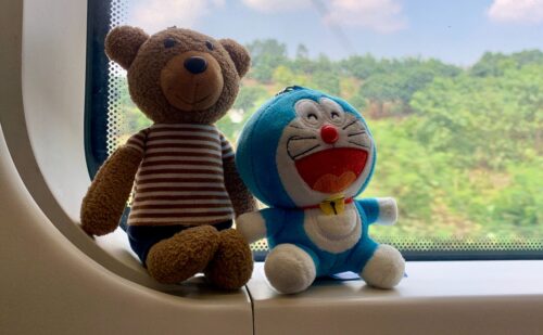 a couple of stuffed animals sitting on top of a window sill