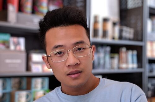 man wearing eyeglasses and blue shirt inside coffee shop