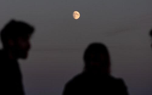 moon in the background of a man and a woman