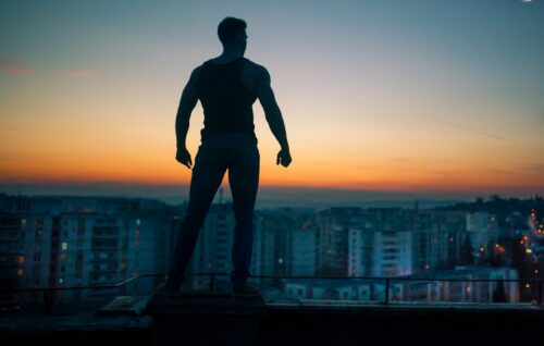silhouette photography standing on peak front of high-rise buildings