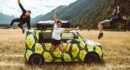 man in black t-shirt and black shorts standing beside green and black jeep wrangler